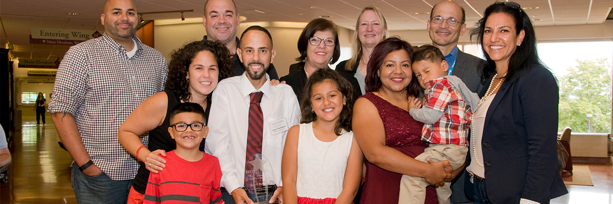 Former patient surrounded by family after receiving award