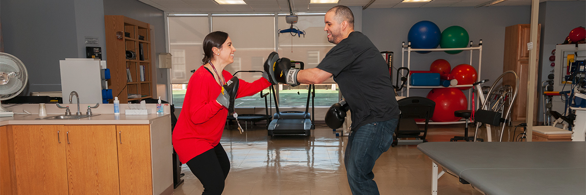 Therapist and patient boxing during outpatient neurological occupational therapy session