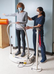 Physical Therapist working with patient using vibration therapy