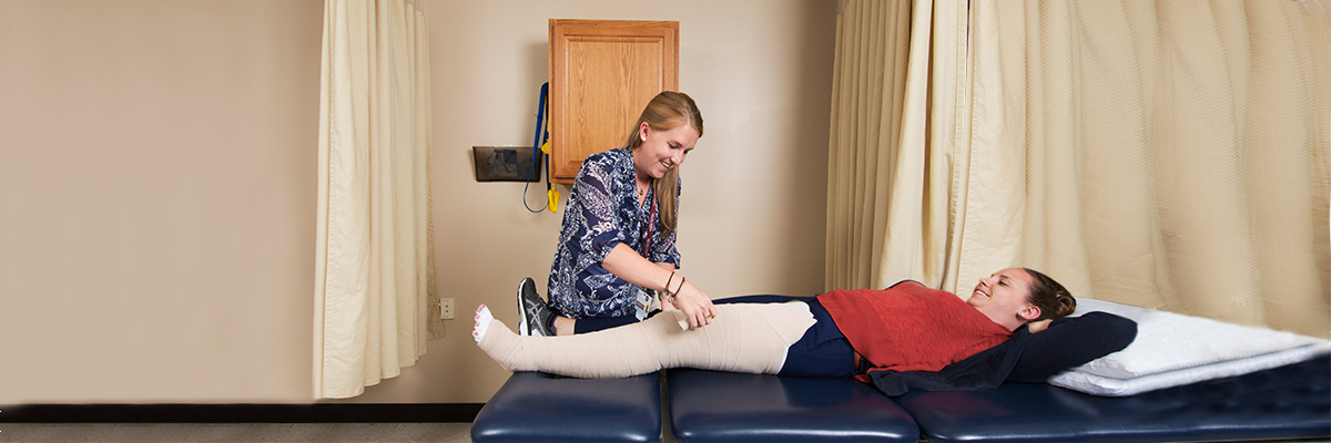 Therapist assisting lymphedema patient with bandage