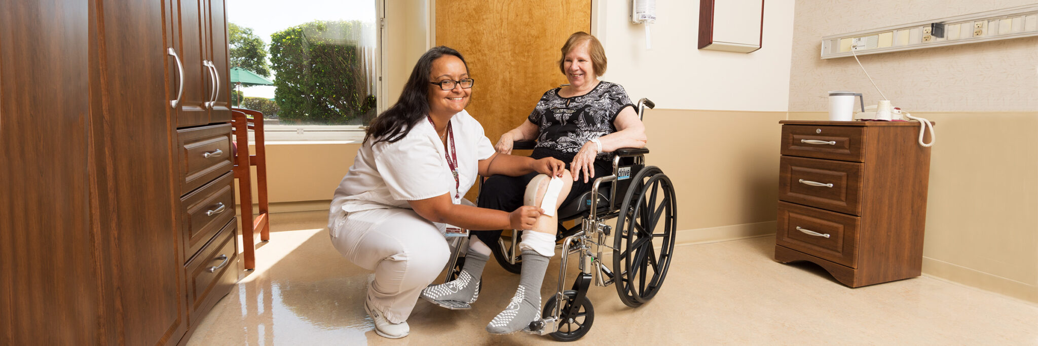 Nurse assisting patient in a wheelchair with bandage