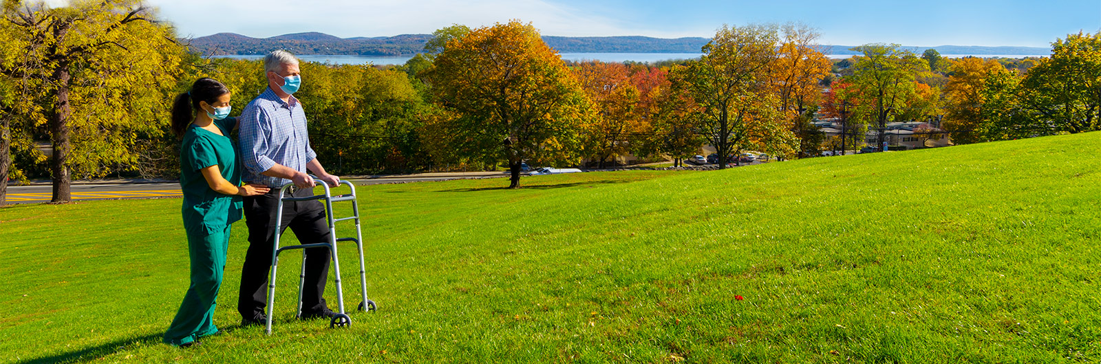 Nurse and Patient with walker outside with views of the river and fall folliage