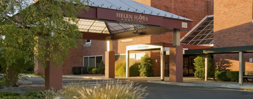 Photo of Helen Hayes Hospital's main entrance. Awning is visible with the name Helen Hayes Hospital, as well as green foliage