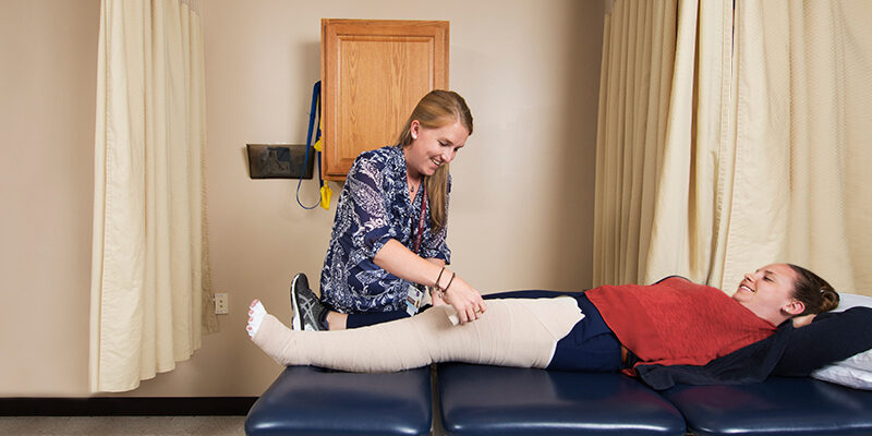 Therapist assisting lymphedema patient with bandage