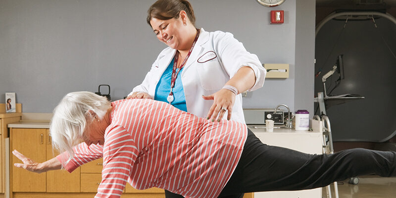 Physical Therapist and patient performing balance and stretching exercises